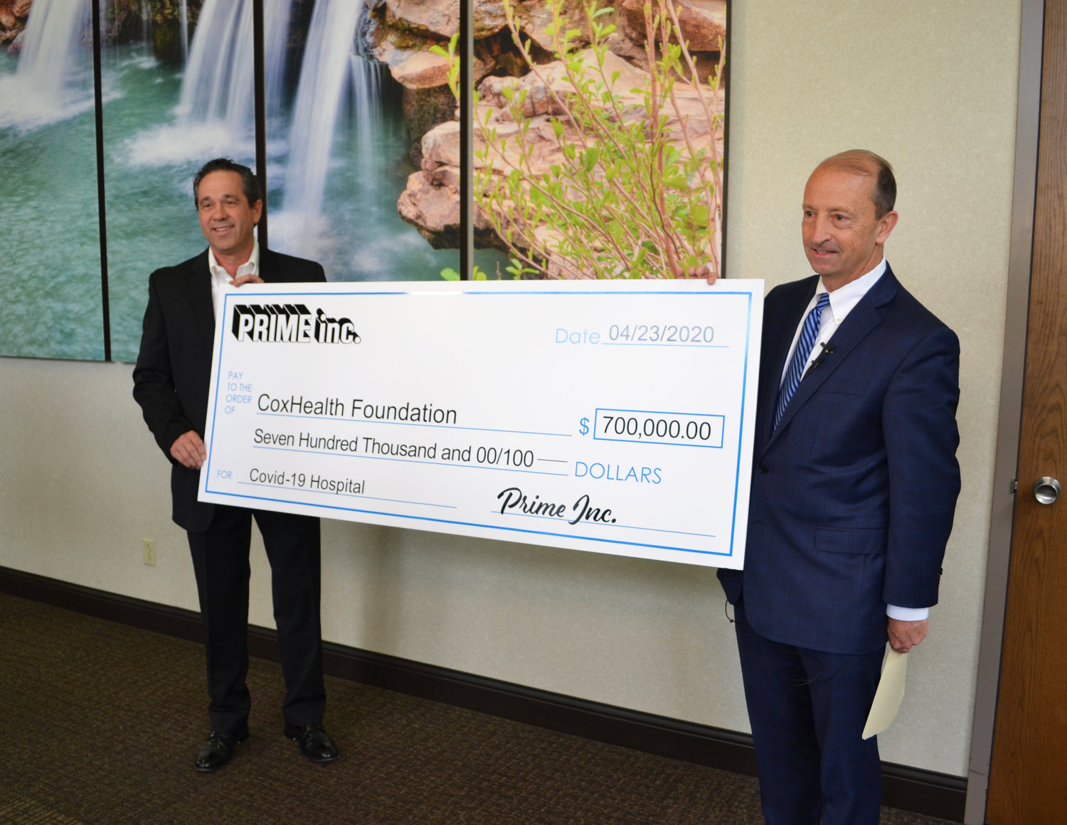 Darrel Hopkins, director of leasing and controller at Prime, left, presents a check to CoxHealth President and CEO Steve Edwards.